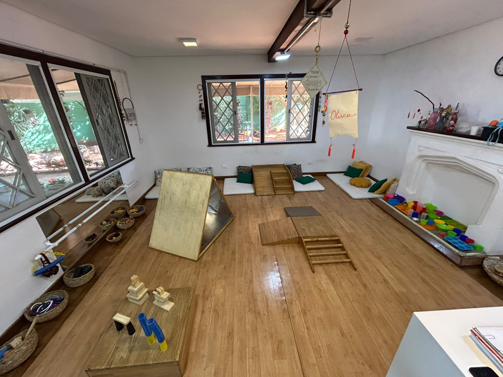 Sala ampla com colchonetes, rampa de madeira e materiais organizados